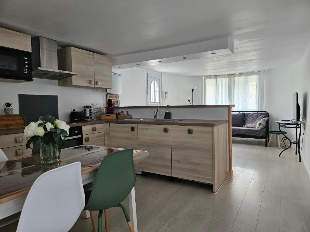 eine Küche mit einem Tisch und Stühlen im Zimmer in der Unterkunft T2 calme et cozy, proche transports in Aulnay-sous-Bois
