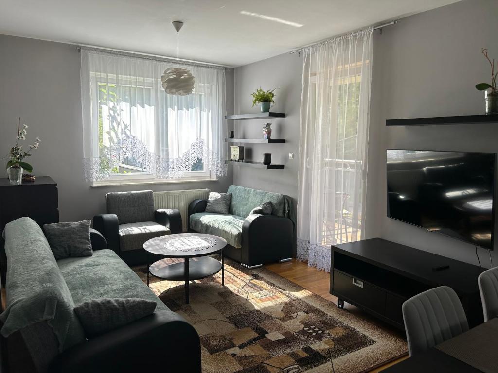a living room with a couch and a tv at Quiet enclave near the airport in Wrocław