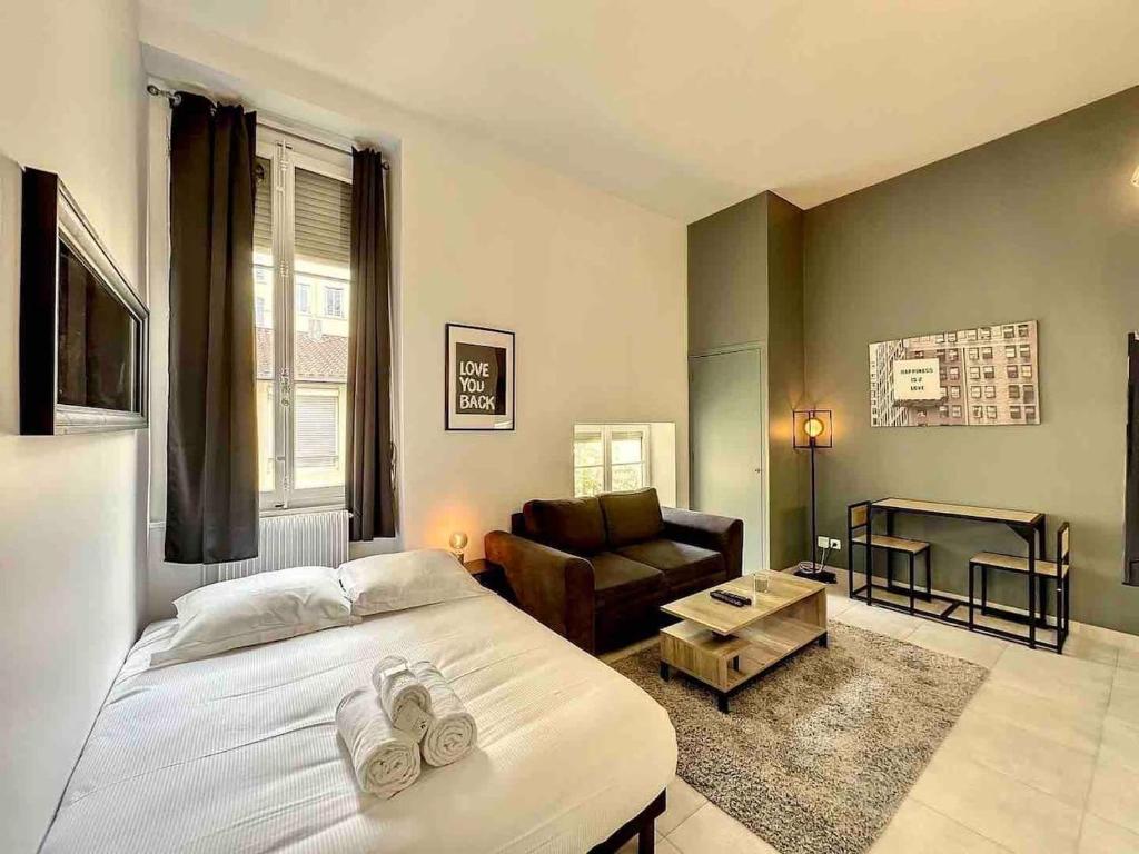 Un dormitorio con una cama y una sala de estar. en Cosy appart Lyon 6/métro foch-bossuet 1, en Lyon