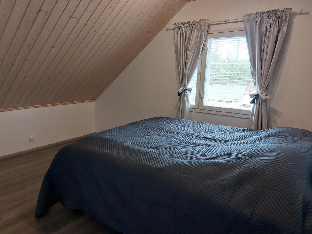 a bedroom with a blue bed and a window at Lomasara in Kalajoki