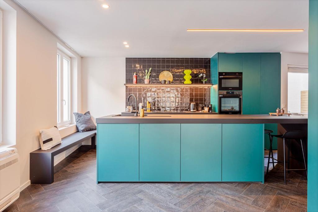 a kitchen with turquoise cabinets and a counter at Uma's Urban Lounge in Mechelen