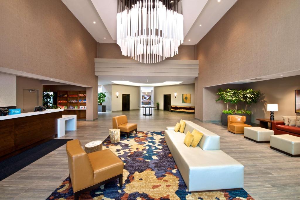 a lobby with a couch and chairs and a chandelier at Embassy Suites by Hilton Seattle North Lynnwood in Lynnwood