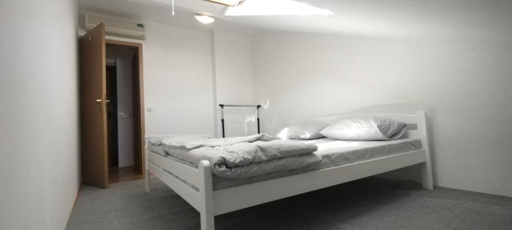 Un dormitorio con una cama blanca con almohadas. en Hostel Center Luxury en Sarajevo