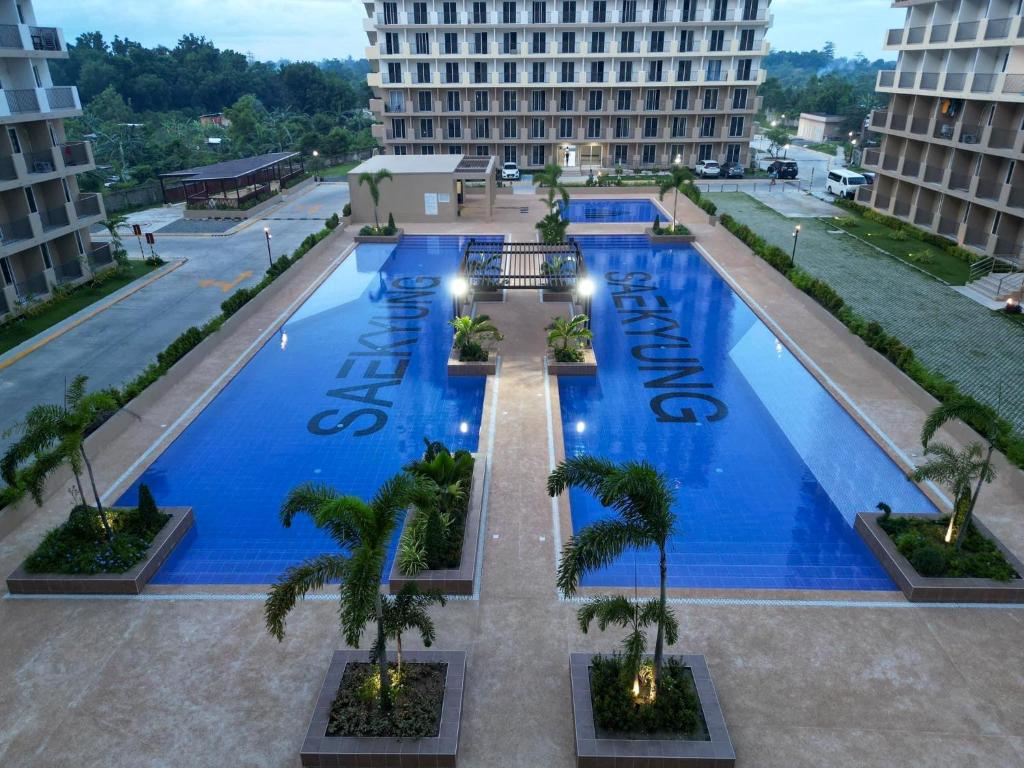 an overhead view of a large swimming pool with palm trees at Seaside Serenity w/ Sunrise @ Saekyung Village One in Lapu Lapu City