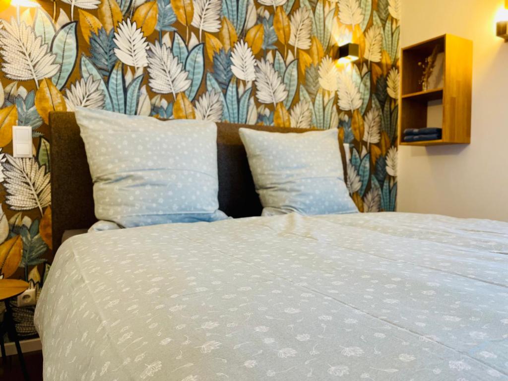 1 dormitorio con 1 cama y papel pintado con motivos florales en die Jungmühle, en Bad Münstereifel