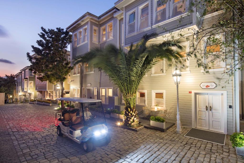 a golf cart parked in front of a building with a palm tree at Hagia Sofia Mansions Istanbul, Curio Collection by Hilton in Istanbul