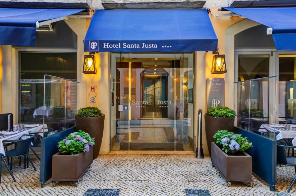 リスボンにあるホテル サンタ ジュスタの青い日よけとテーブルと花のレストランです。