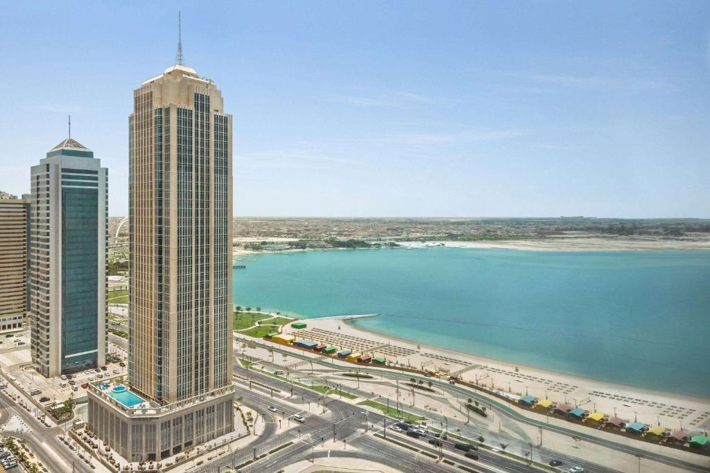 vistas a una ciudad con edificios altos y un cuerpo de agua en Wyndham Grand Doha West Bay Beach, en Doha
