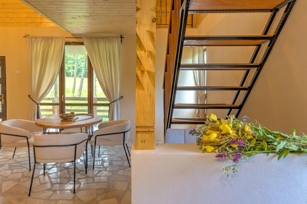 a dining room with a table and chairs and flowers at Satul de vacanta Cuibul Lupilor in Ciucea