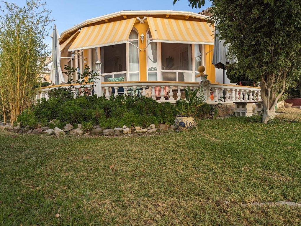 a house with a yellow roof and a yard at Villa Carmen in Torrox Costa