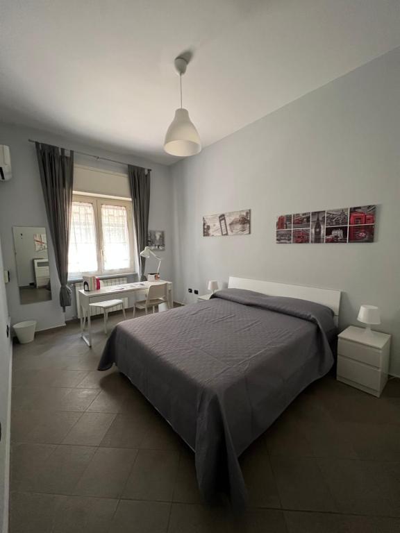 1 dormitorio con 1 cama grande y escritorio en Centrocentro Casa Vacanze, en Avellino