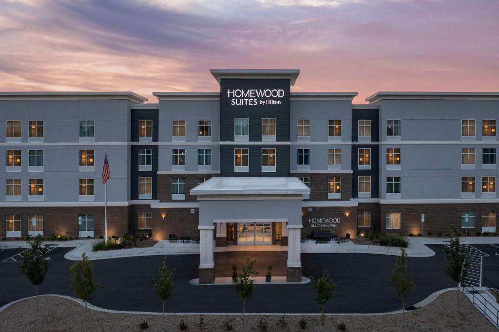 una representación de la parte delantera de un hotel con puesta de sol en Homewood Suites By Hilton Greenville, NC, en Greenville
