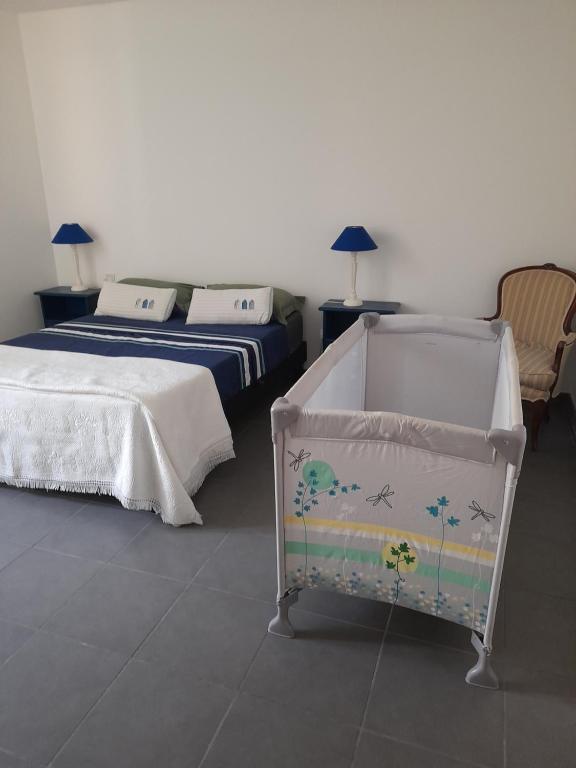 1 dormitorio con 2 camas y 1 cuna en La petite Pèlerine, en Narbona