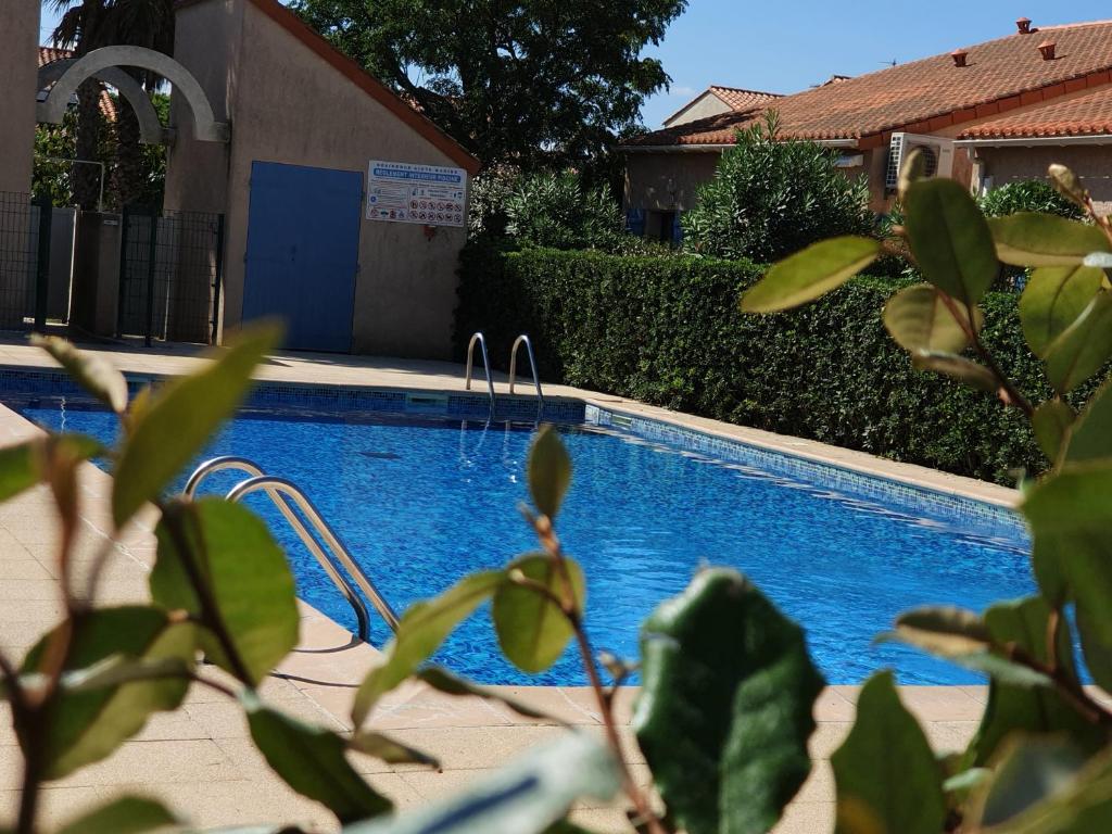 a swimming pool in front of a house at Aigue Marine. in Canet-en-Roussillon