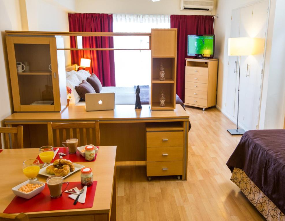 una habitación con una cama y una mesa con comida. en Callao Suites Recoleta en Buenos Aires