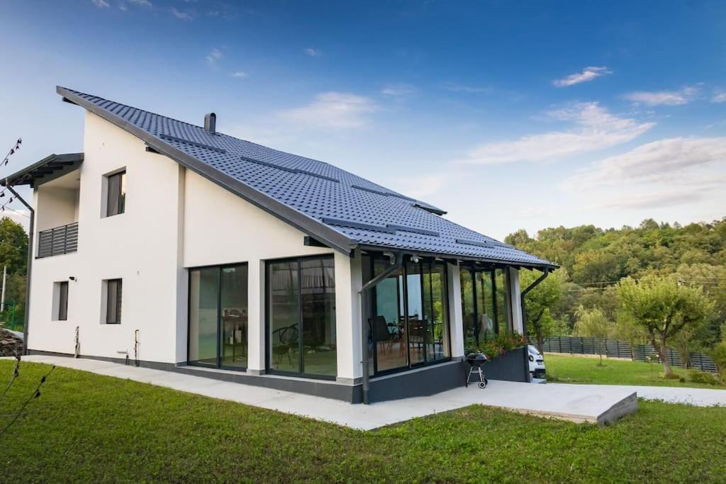 a large white house with a solar roof at Vila MOON in Bezdead