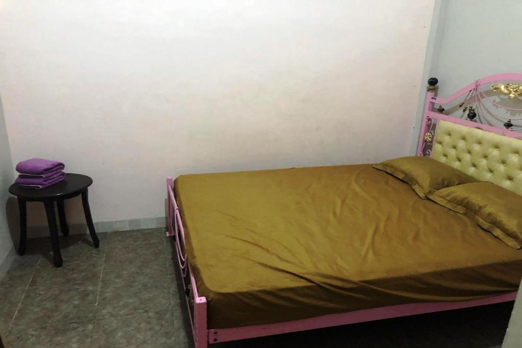 Schlafzimmer mit einem Bett und einem Beistelltisch in der Unterkunft SPOT ON 93014 Griya Nautika Sukodono in Sidoarjo