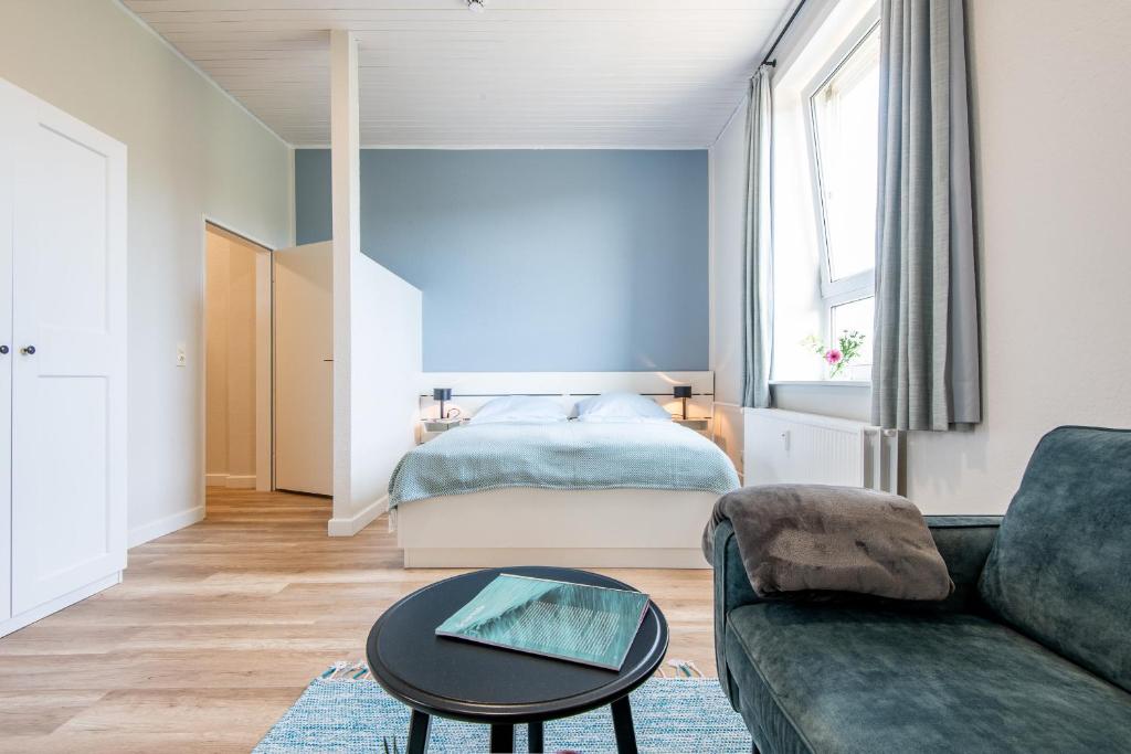 een woonkamer met een bank en een bed bij Steger-Hüs Wohnung 20 in Rantum