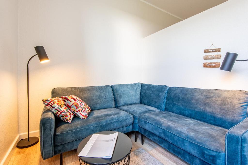 a living room with a blue couch and a table at Steger-Hüs Wohnung 25 in Rantum