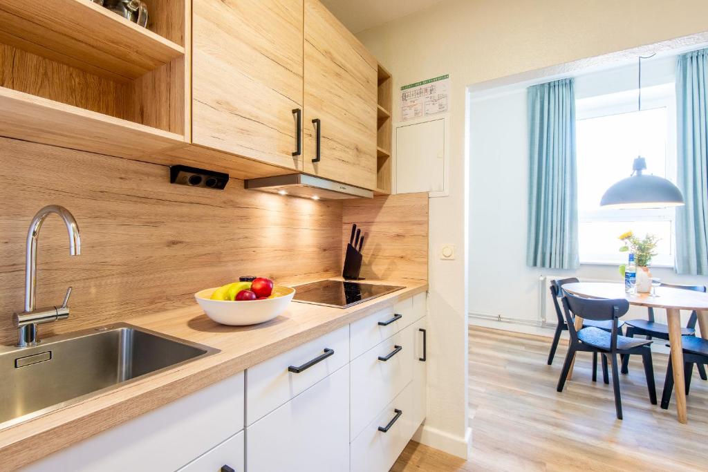 a kitchen with a sink and a bowl of fruit on the counter at Steger-Hüs Wohnung 18 in Rantum