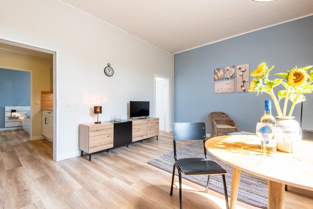 a living room with a table and chairs and a television at Steger-Hüs Wohnung 19 in Rantum