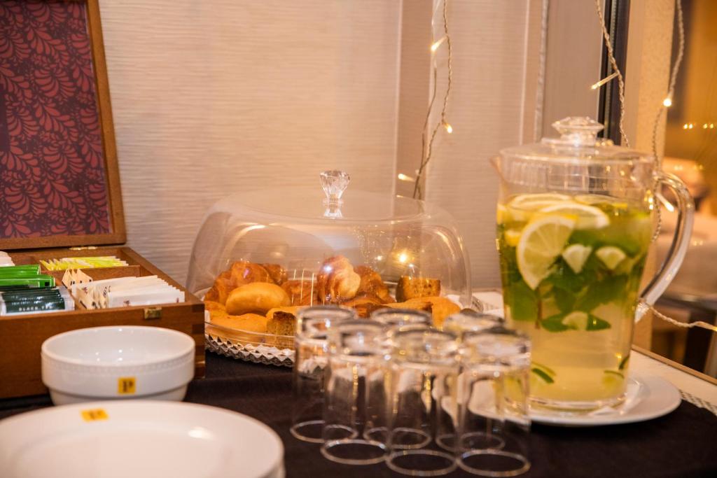 A breakfast table set with pastries, lemonade and glassware.