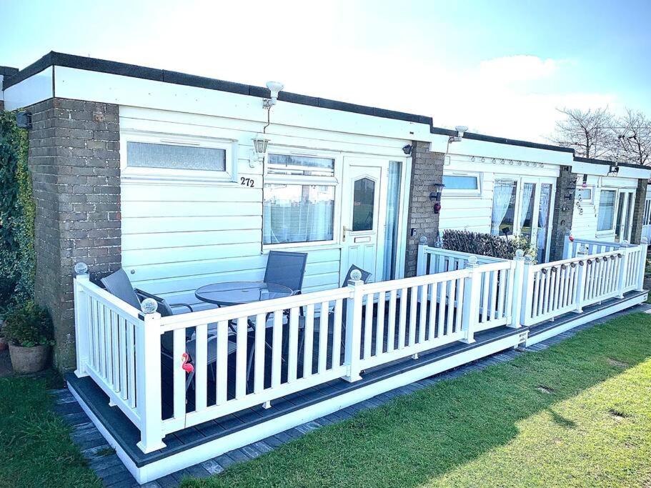 Casa móvil con porche y valla blanca en Classic Seaside Holiday Home in Hemsby, en Hemsby