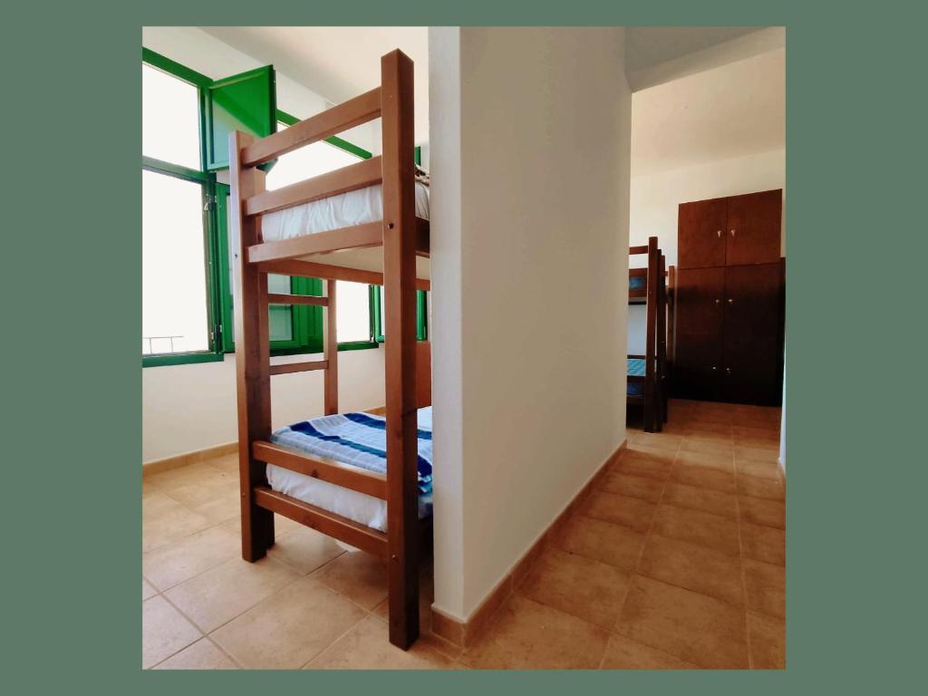 El TabladoにあるHostal Albergue Garafía El Tabladoのはしご付きの部屋の二段ベッド1台分です。