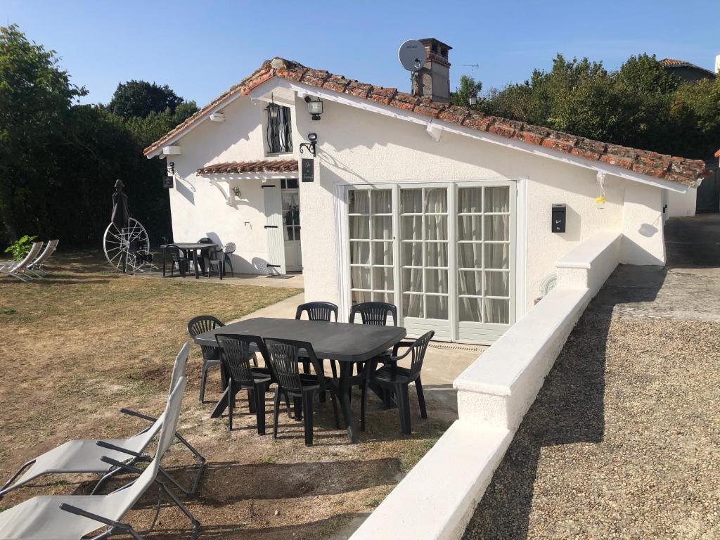 een tafel en stoelen voor een huis bij Gîte des Tournesols in Oradour-Fanais