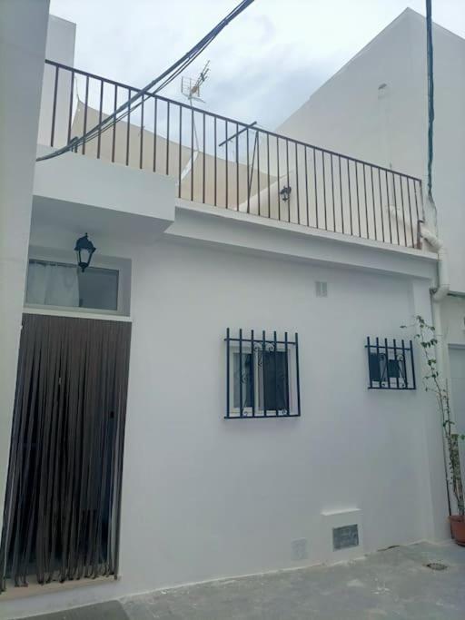 a white building with a staircase and windows at Castelar in Rota