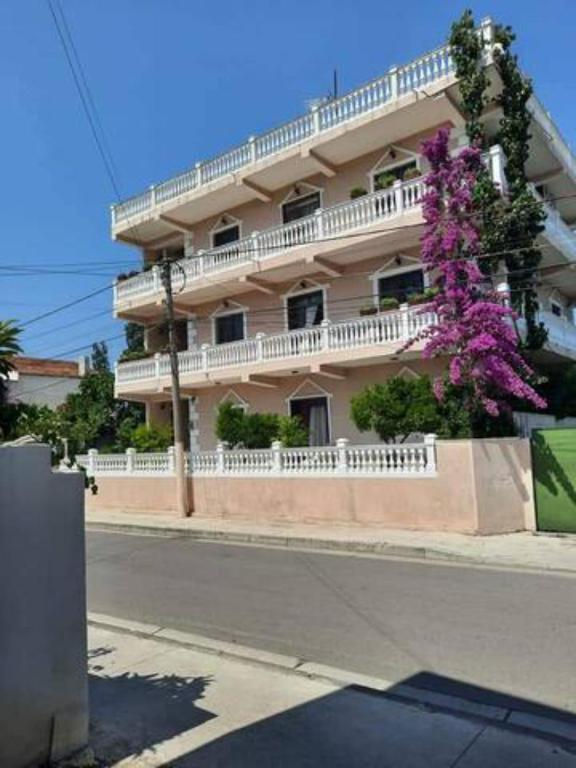 a building with a flowering tree in front of it at Vila Lika Durres in Durrës