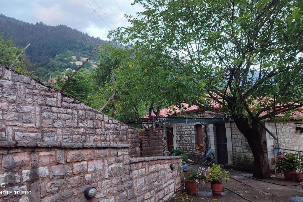 a house with a brick wall and a tree at ΜΑΡΙΓΟΥΛΑΜ in Kalesménon