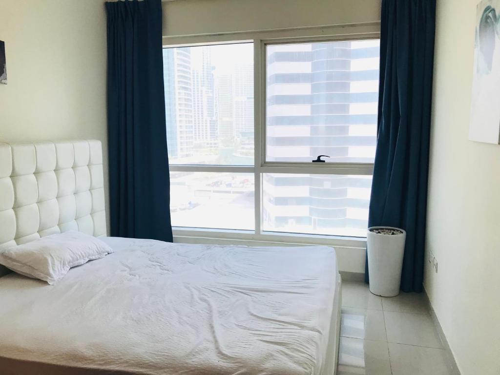 a bed in a room with a large window at Apartment in Dubai