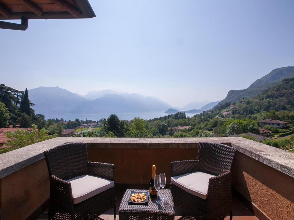 a balcony with two chairs and a table with wine glasses at Villa Lakecomo - Ritrovo in Menaggio