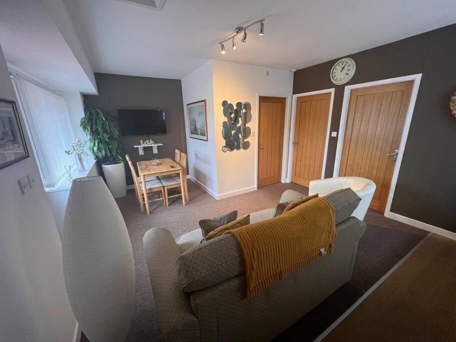ein Wohnzimmer mit einem Sofa und einem Tisch in der Unterkunft Private Annex with Two Bedrooms in Upton