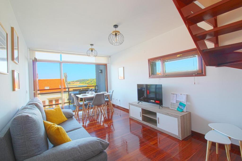 a living room with a couch and a tv at El Rincón del Mar in San Vicente de la Barquera
