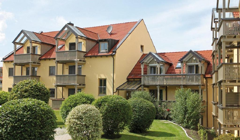 eine Reihe von Häusern mit Büschen und Bäumen in der Unterkunft Appartementhaus Würding in Bad Füssing