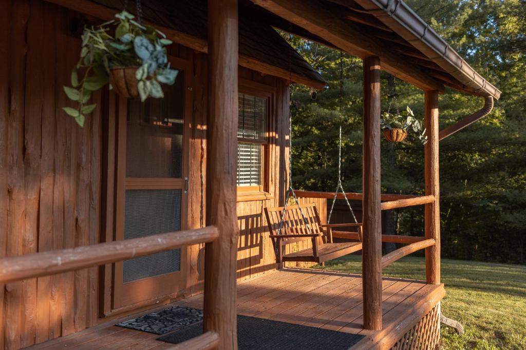 a porch of a log cabin with a swing at Athens and Albany's Hillside Haven - peaceful, private, pet friendly in Albany