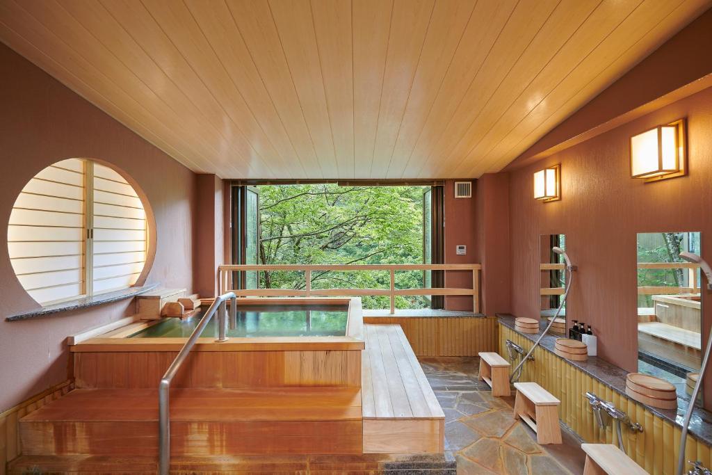 a large bathroom with a hot tub and a window at 日光ガーデンホテル in Nasushiobara