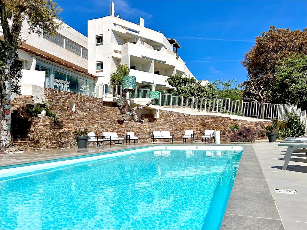 une piscine en face d'un bâtiment dans l'établissement Hotel La Voile, à Bormes-les-Mimosas