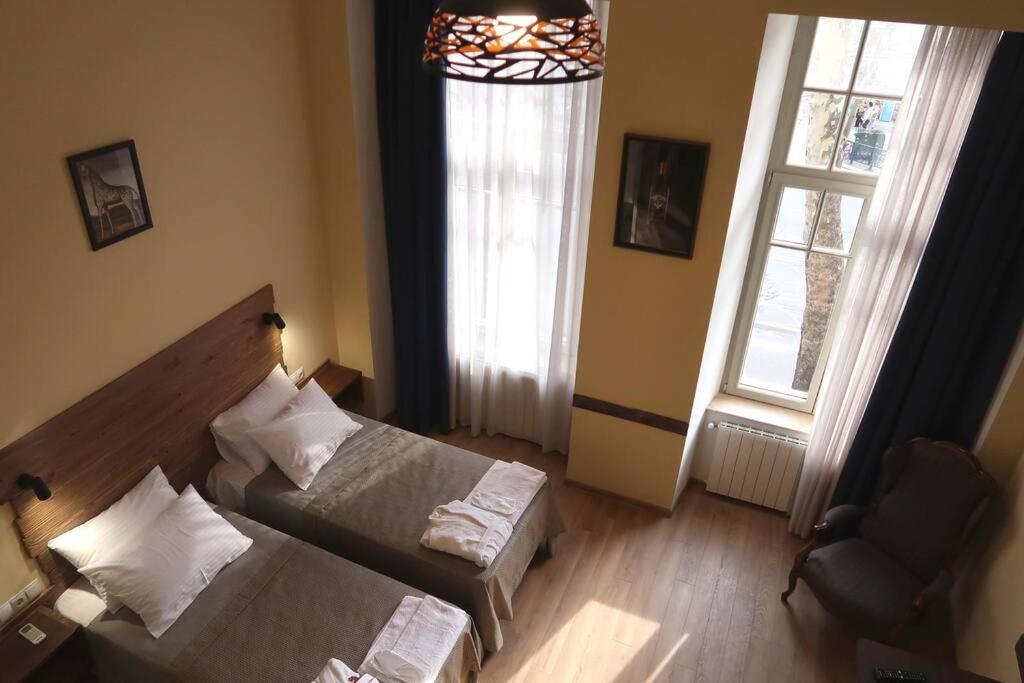 1 dormitorio con 1 cama, 1 silla y 1 ventana en Opera Garden Apartment 2 in Tbilisi center, en Tiflis