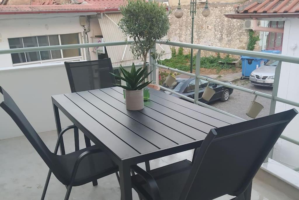 a table and chairs on a balcony with a potted plant at Plane Tree House in Próti