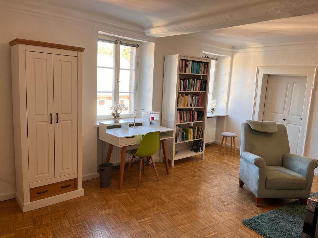 a room with a desk and a chair and a book shelf at Wohnen im idyllischen Schlosshof in Franken in Ebern