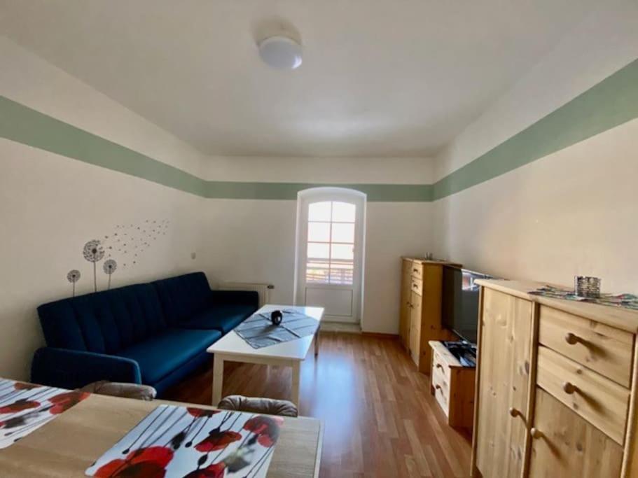 een woonkamer met een blauwe bank en een tafel bij Wanderurlaub mit Hund in Harra
