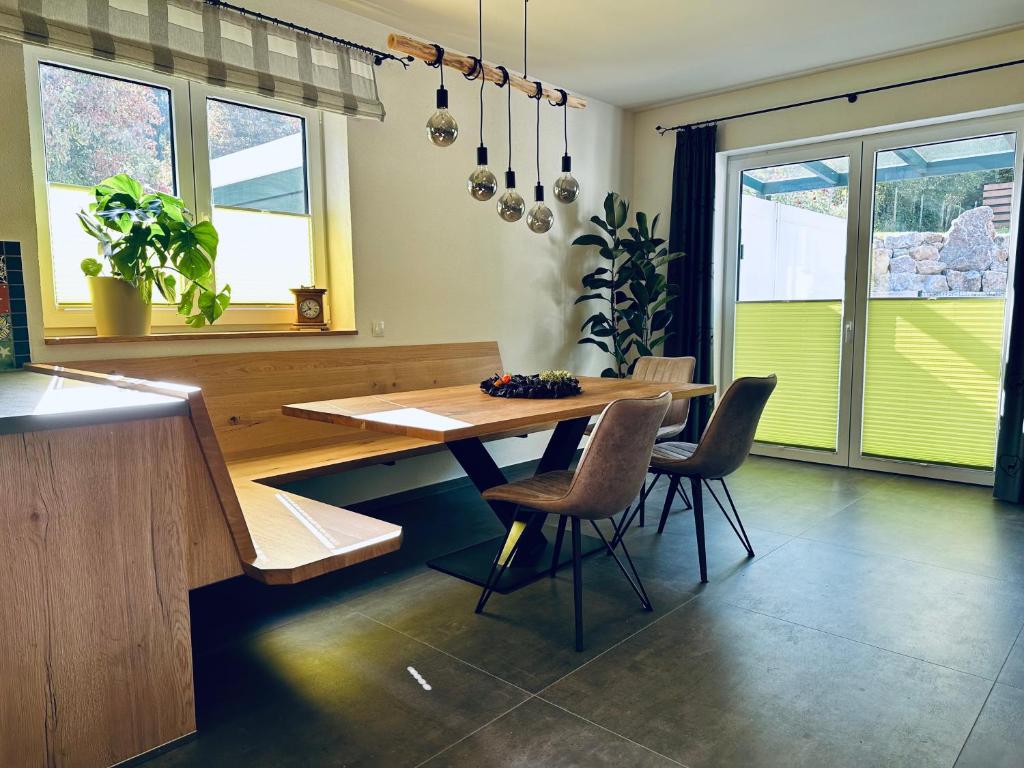 uma sala de jantar com uma mesa de madeira e cadeiras em Traumferienhaus Leimbach am Nürburgring em Leimbach