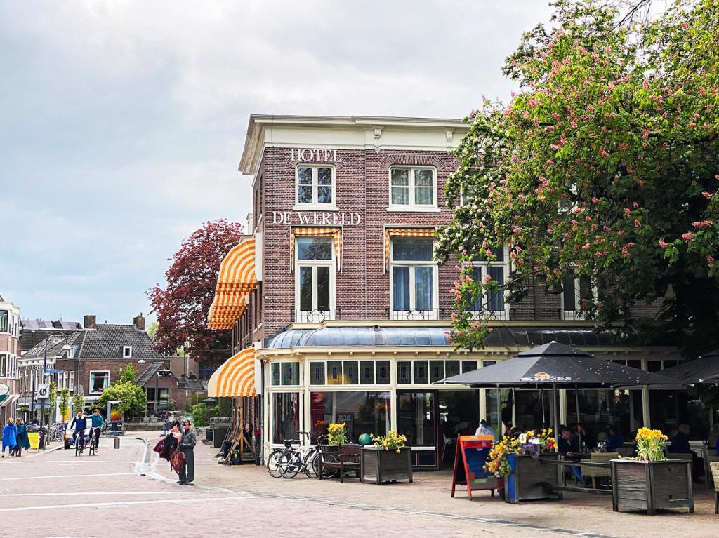 een gebouw op een straat waar mensen voor lopen bij Hotel de Wereld in Wageningen
