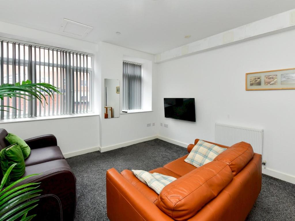 een woonkamer met een oranje bank en een tv bij Pass the Keys Sleeps 5 close to Bay City in Cardiff