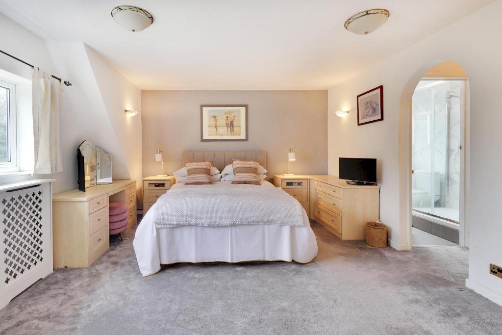 a large bedroom with a bed and a television at Pass the Keys Large family home in picturesque village in Westerham