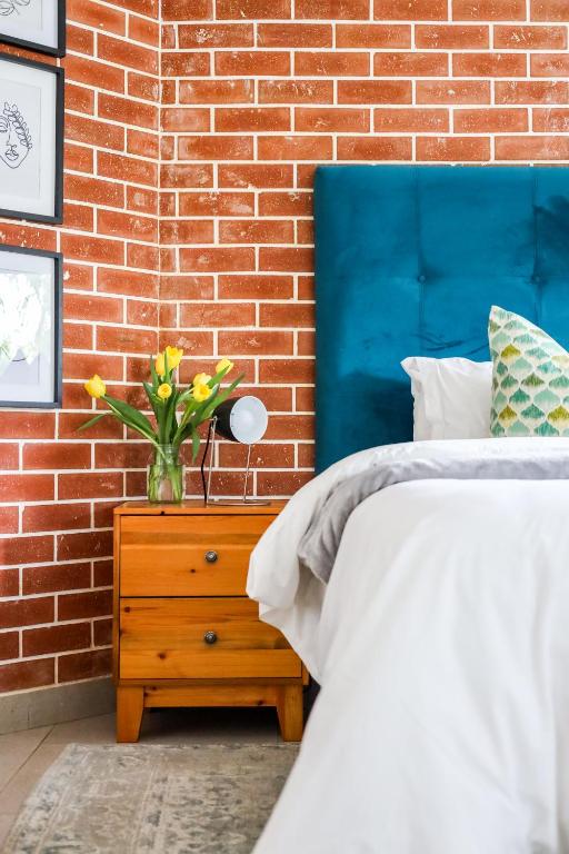 a bedroom with a bed and a brick wall at The Blue Door Guesthouse in East London
