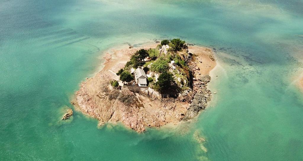 une île dans l'eau avec une maison sur elle dans l'établissement Évasion Prestige sur l'Île Koeur, à Lézardrieux